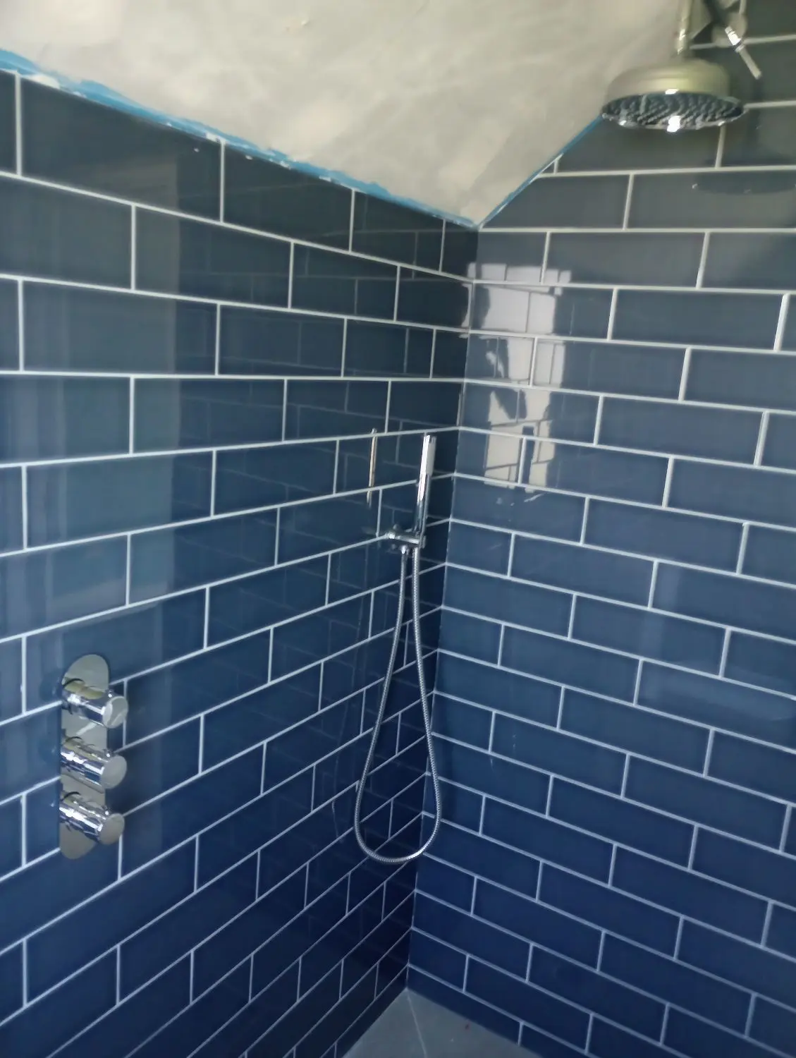 Accessible blue-tiled shower installation