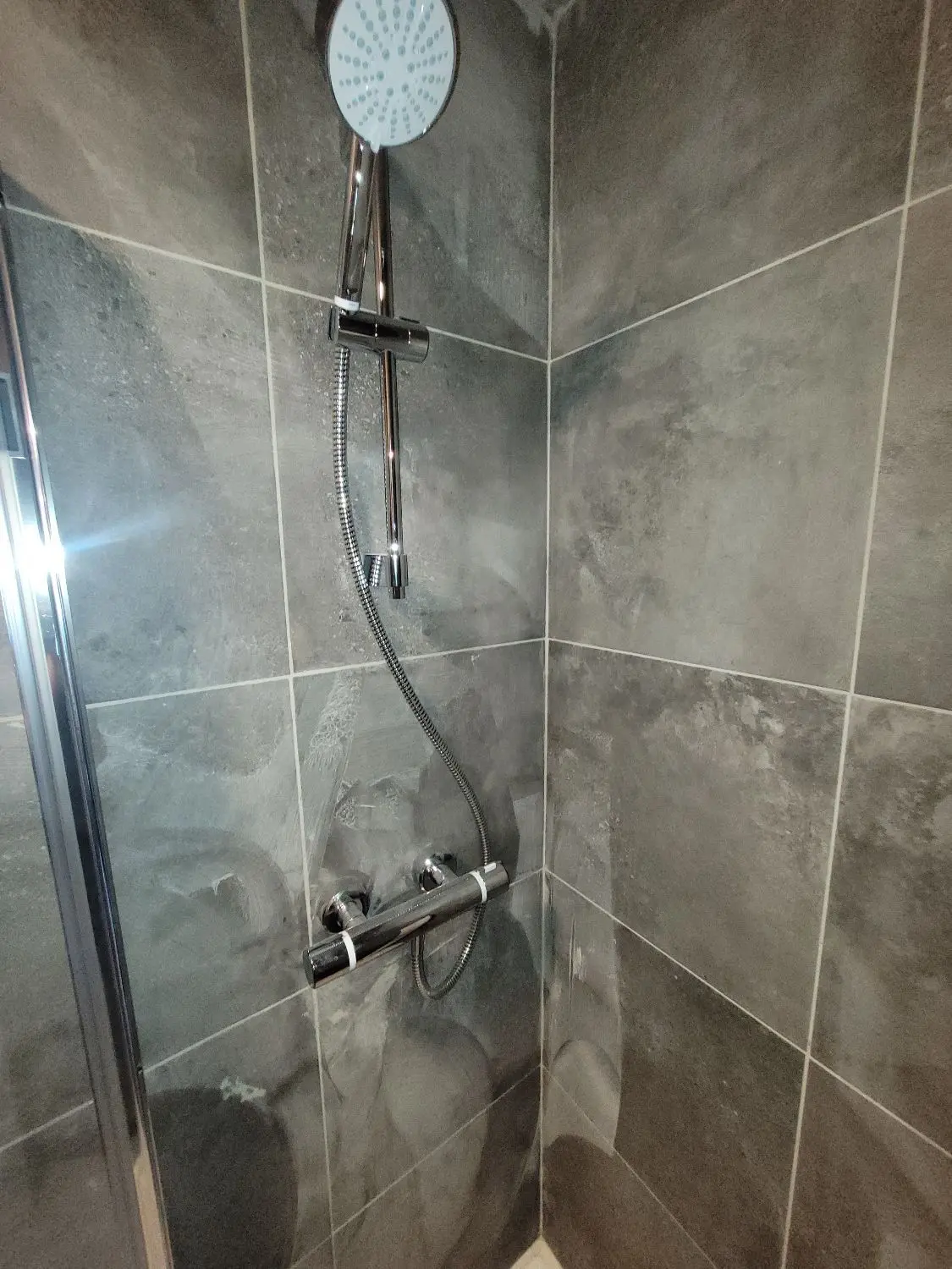 Grey tiled walk-in shower completed by Palco